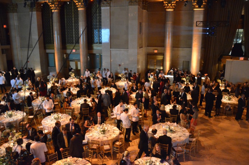 Φωτογραφία τραβηγμένη από ψηλά που δείχνει μια αίθουσα με τραπέζια δεξιώσεων και τον κόσμο να περιφέρεται γύρω από τα τραπέζια