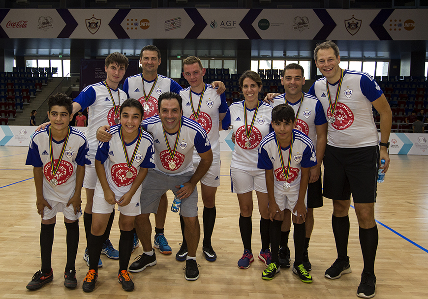 Members of the Stavros Niarchos Foundation and Special Olympics wearing matching shirts smile for the camera