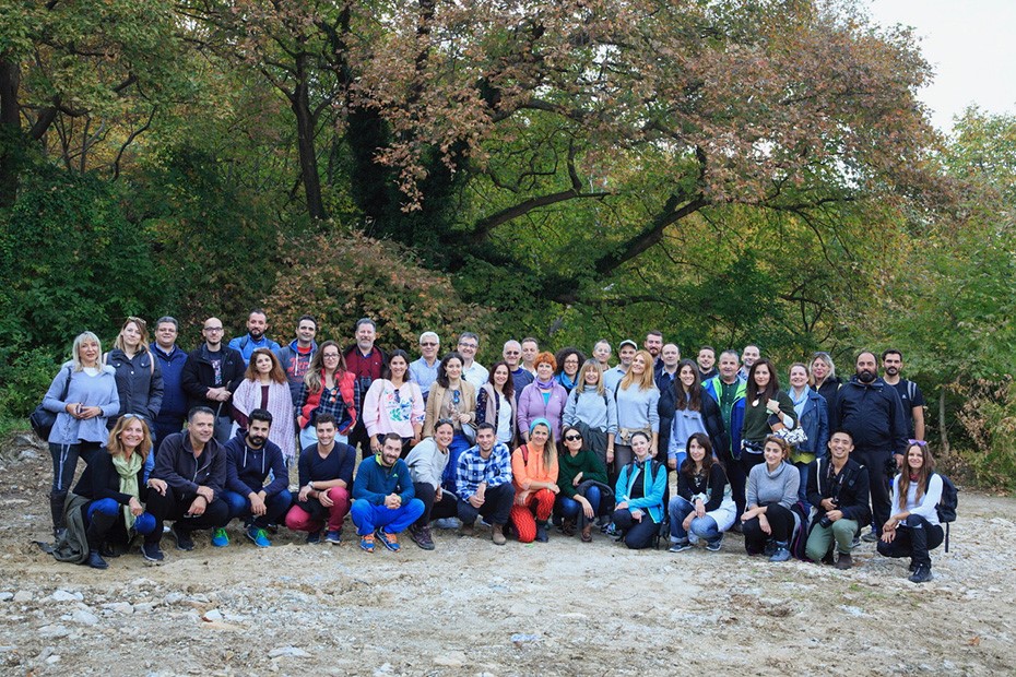 Πλήθος ανθρώπων χαμογελάει για μια αναμνηστική φωτογραφία σε ένα μονοπάτι στο δάσος