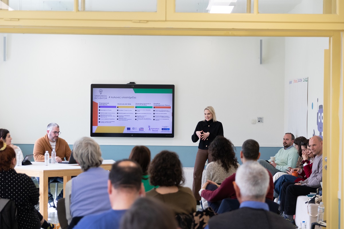 Μία γυναίκα κάνει παρουσίαση μπροστά από το καθισμένο κοινό.