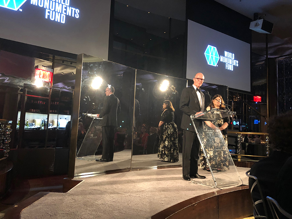 Ένας άνδρας στη σκηνή μπροστά από έναν τρίπλευρο καθρέφτη στο Hadrian Gala 2018 του Παγκόσμιου Ταμείου Μνημείων