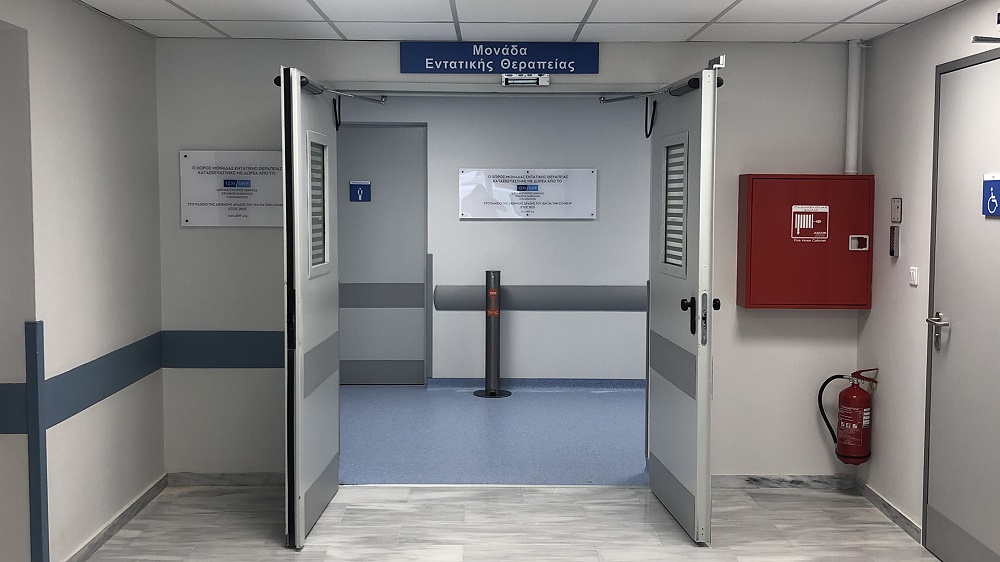 Φωτογραφία από το εσωτερικό ενός νοσοκομείο στην οποία φαίνεται μια ανοιχτή πόρτα με επιγραφή από πάνω που λέει Μονάδα Εντατικής Θεραπείας καθώς και επγραφή που αναφέρει ότι είναι δωρεά του Ιδρύματος Σταύρος Νιάρχος 