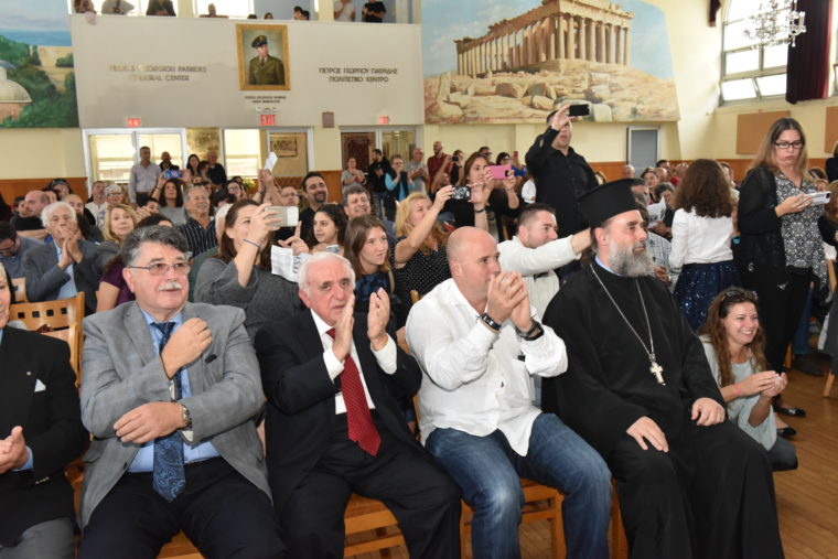 Ο Αντρέας Δρακόπουλος, Πρόεδρος του Ιδρύματος Σταύρος Νιάρχος κάθεται στην πρώτη σειρά και χειροκροτά καθώς ο κόσμος που κάθεται πίσω του βγάζει φωτογραφίες 