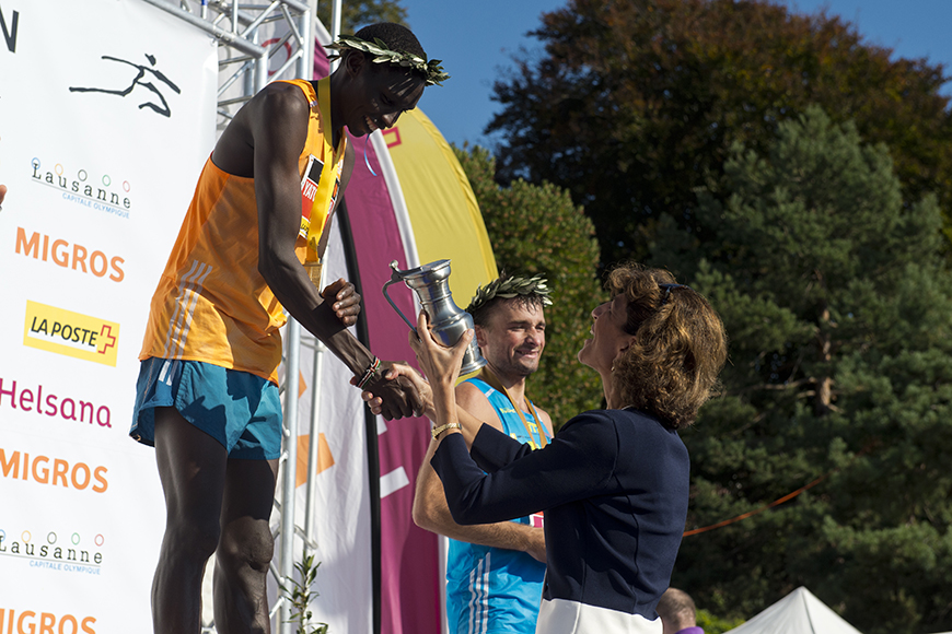 Μια γυναίκα δίνει στον αθλητή που νίκησε την πρώτη θέση ένα ασημένιο κύπελλο