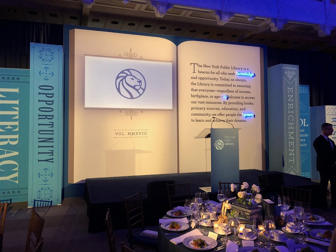 Η σκηνή στο γκαλά της Δημόσιας Βιβλιοθήκης της Νέας Υόρκης έχει ως φόντο ένα μεγάλο βιβλίο με ένα απόσπασμα σχετικά με την αποστολή της βιβλιοθήκης για την προσβασιμότητα