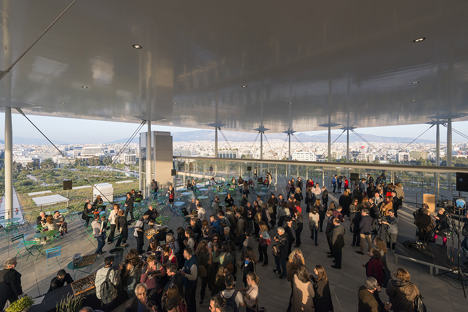 Φωτογραφία που απεικονίζει πλήθος κόσμου να βρίσκεται στον ημιυπαίθριο χώρο ενός κτηρίου και να κοιτάει τη θέα