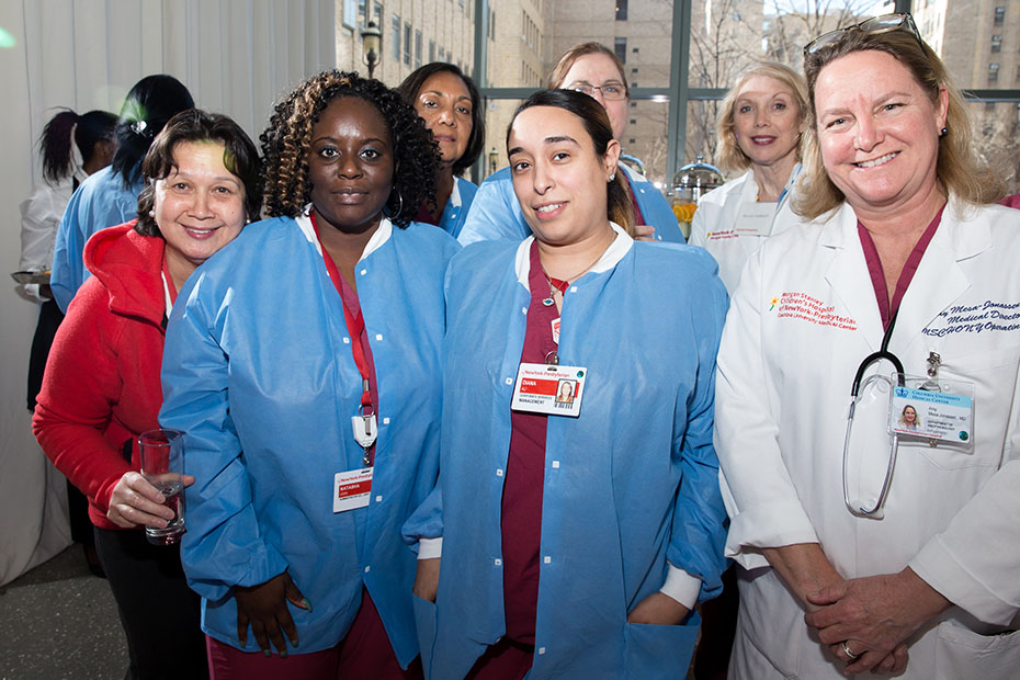 Μια ομάδα γυναικών του νοσοκομείου New York-Presbyterian χαμογελούν και φωτογραφίζονται μαζί