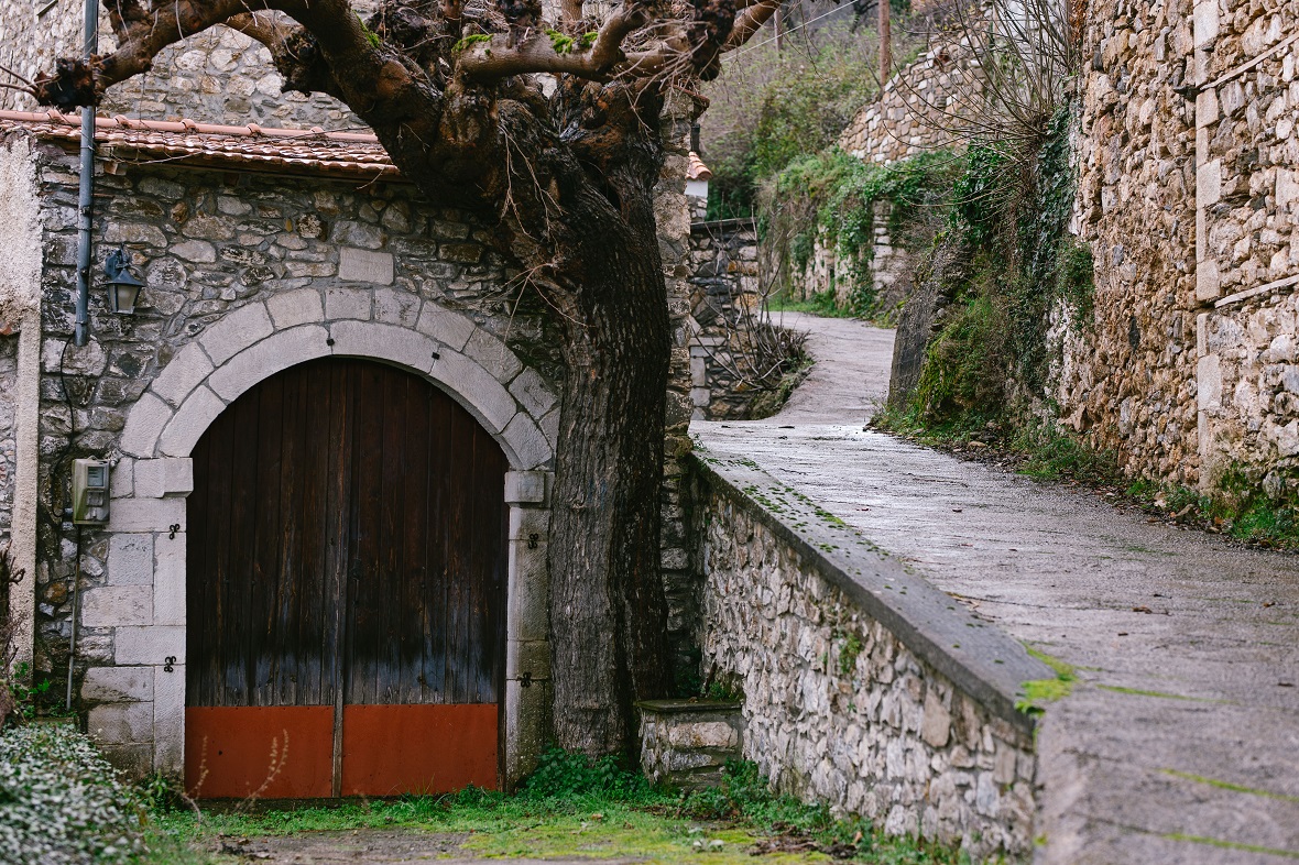Φωτογραφία που δείχνει ένα πέτρινο σπιτάκι δίπλα από μια ανηφόρα στο χωριό