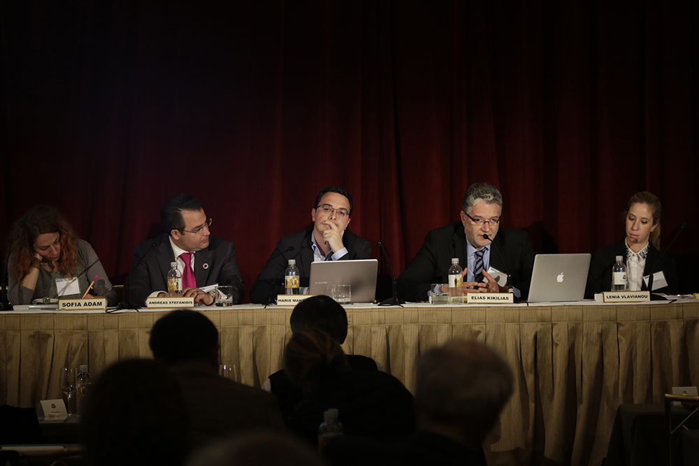 Πέντε μέλη του συνεδρίου κάθονται σε ένα τραπέζι και μιλούν μπροστά σε κοινό