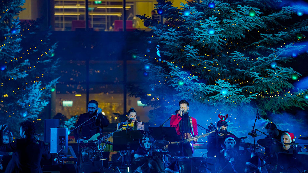 Μια μπάντα παίζει μπροστά από στολισμένα δέντρα στο Κέντρο Πολιτισμού Ίδρυμα Σταύρος Νιάρχος