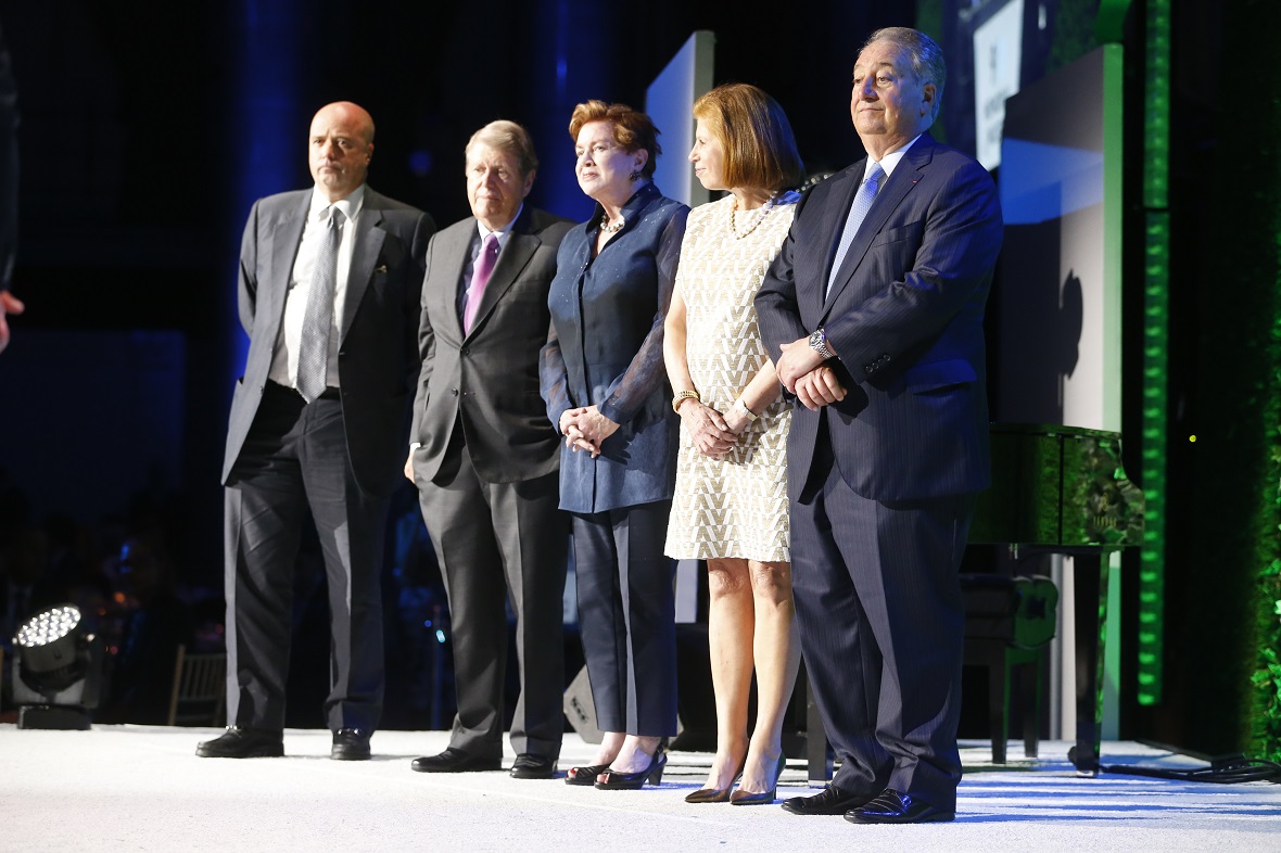Five people stand up on stage next to each other for a commemorative photo