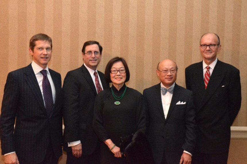 Τέσσερις άντρες και μια γυναίκα στέκονται για μια αναμνηστική φωτογραφία