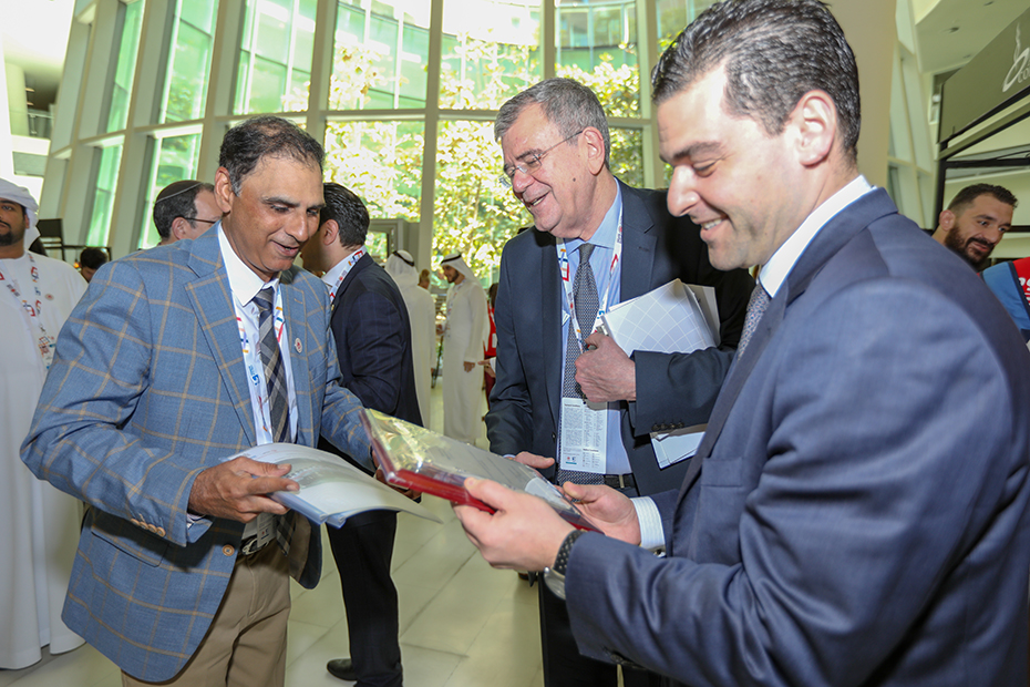 Οι συμμετέχοντες στην Παγκόσμια Σύνοδο Κορυφής για την Ηγεσία των Νέων και τα μέλη του Ιδρύματος Σταύρος Νιάρχος χαμογελούν και δείχνουν ο ένας στον άλλον διάφορα βιβλία