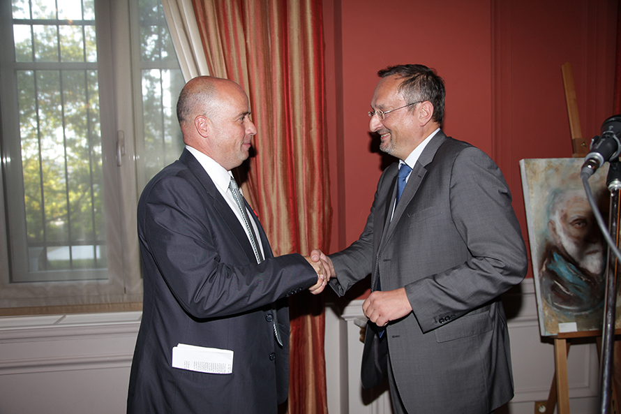 Ο Ανδρέας Δρακόπουλος, πρόεδρος του Ιδρύματος Σταύρος Νιάρχος, σφίγγει το χέρι ενός άνδρα και χαμογελάει