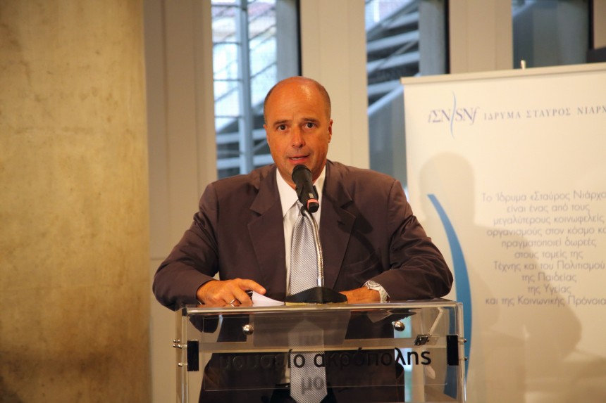 Ο Αντρέας Δρακόπουλος, Πρόεδρος του Ιδρύματος Σταύρος Νιάρχος, μιλάει στο βήμα και πίσω του υπάρχει ένα banner που έχει το λογότυπο του Ιδρύματος Σταύρος Νιάρχος