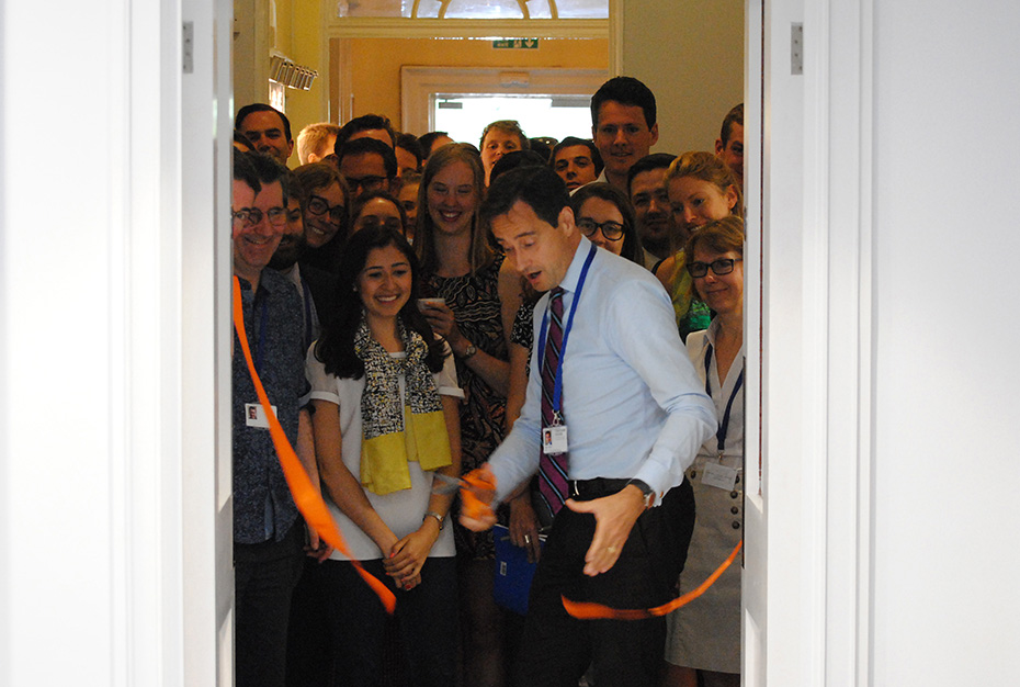 Ένα μέλος του προσωπικού του Chatham House κόβει την κορδέλα των εγκαινίων του ορόφου του Ιδρύματος Σταύρος Νιάρχος