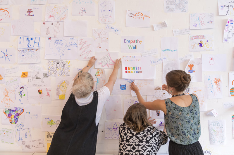 Τρεις γυναίκες γεμίζουν έναν τοίχο με τίτλο 