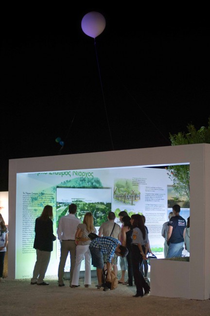 Σε έναν εξωτερικό χώρο έχει τοποθετηθεί μια κατασκευή σαν ένα ανοιχτό σπίτι στους τοίχους του οποίου υπάρχουν φωτογραφίες και σχόλια και ο κόσμος τα κοιτάει