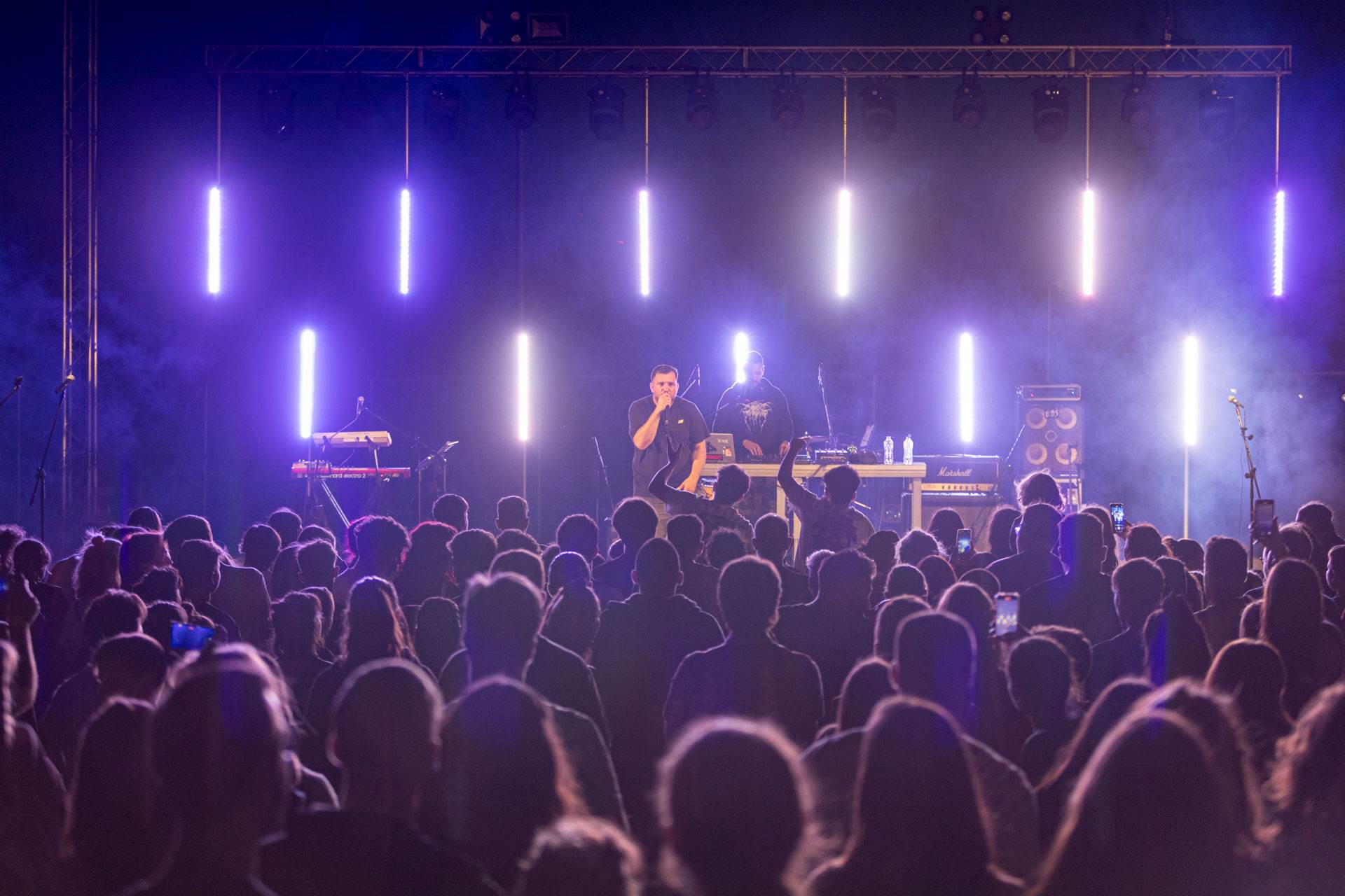 Ένα πλήθος ανθρώπων που ακούει έναν τραγουδιστή στη σκηνή.