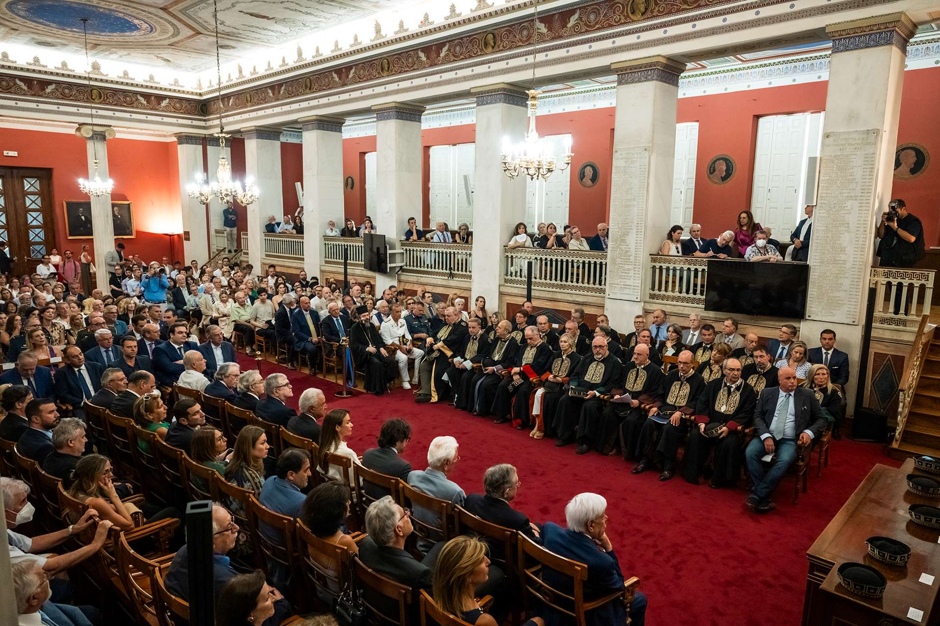 Φωτογραφία του κοινού, που κάθεται στις θέσεις του στη μεγαλοπρεπή Μεγάλη Αίθουσα του ΕΚΠΑ, κατά τη διάρκεια της τελετής