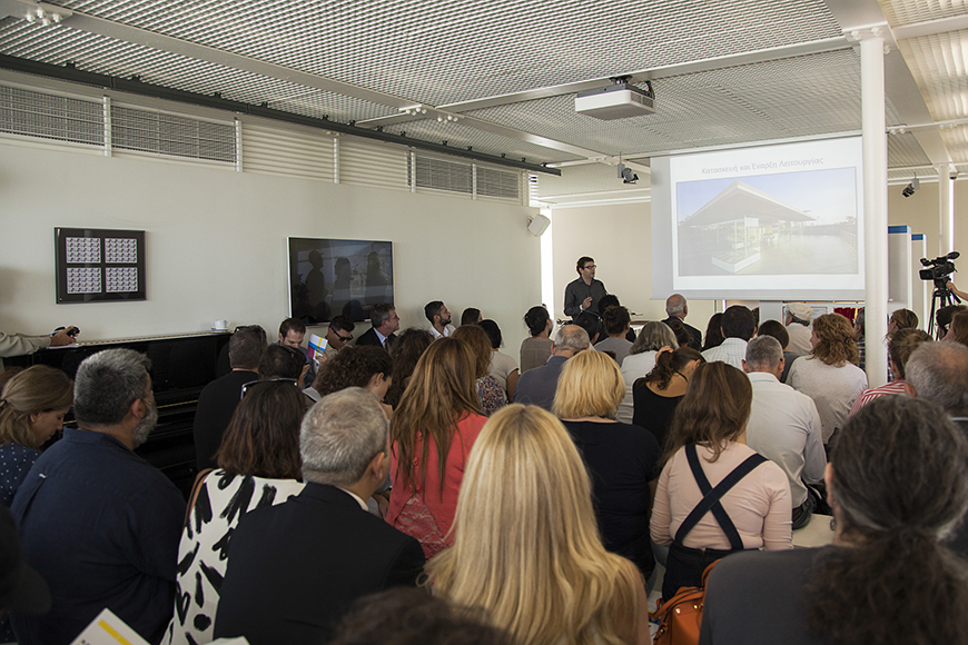 Μια ομάδα ανθρώπων παρακολουθούν μια ομιλία και κοιτούν την εικόνα που προβάλλεται στον προτζέκτορα