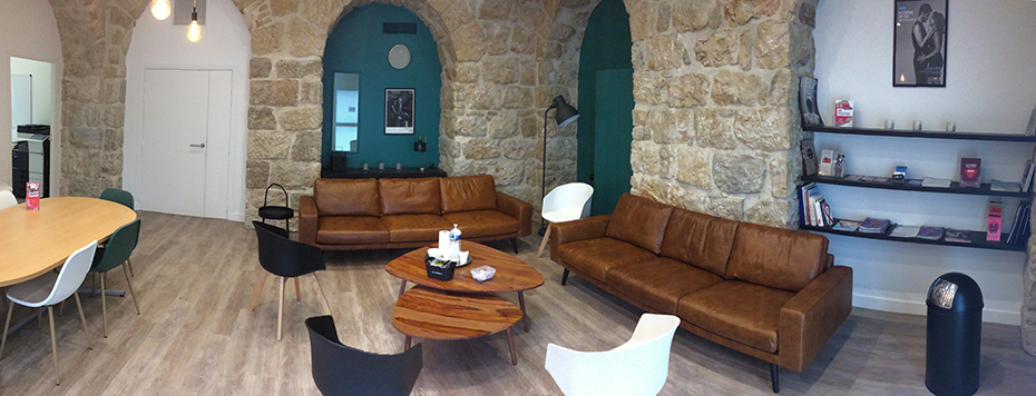 Φωτογραφία που δείχνει τον εσωτερικό χώρο ενός δωματίου όπου υπάρχυν πέτρινοι τοίχοι και δύο καναπέδες οι οποίοι έχουν μπροστά τους ένα τραπέζι 