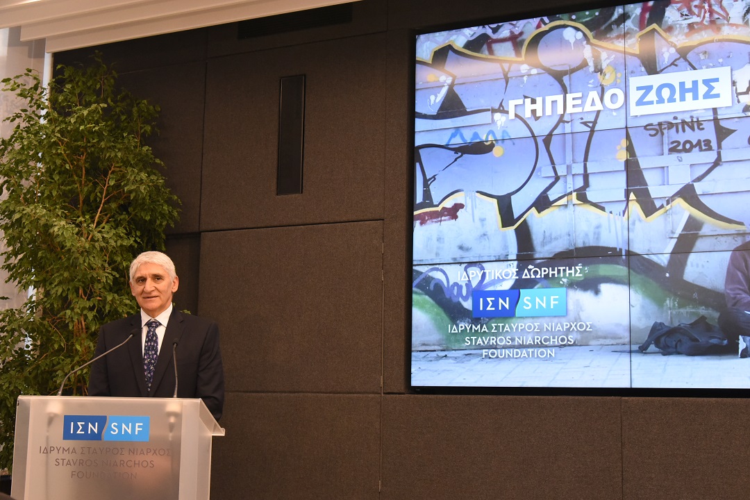 Ένας άντρας στέκεται στο βήμα του Ιδρύματος Σταύρος Νιάρχος και δίπλα του στην οθόνη γράφει ΓΗΠΕΔΟ ΖΩΗΣ ΙΔΡΥΤΙΚΟΣ ΔΩΡΗΤΗΣ ΙΔΡΥΜΑ ΣΤΑΥΡΟΣ ΝΙΑΡΧΟΣ 