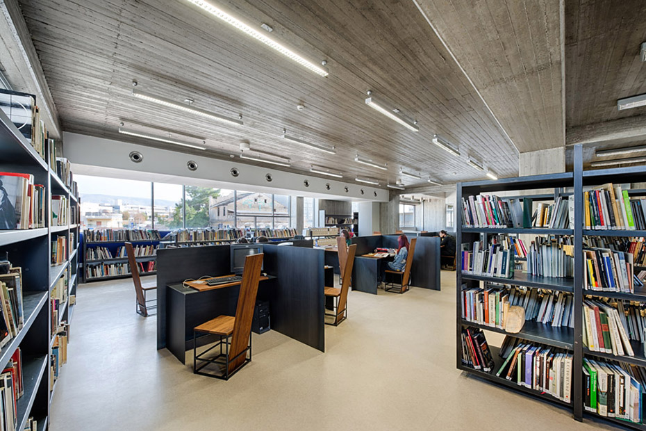 Φωτογραφία που δείχνει τα ράφια γεμάτα με βιβλία και τα ατομικά γραφεία τα οποία υπάρχουν στον εσωτερικό χώρο μιας βιβλιοθήκης 