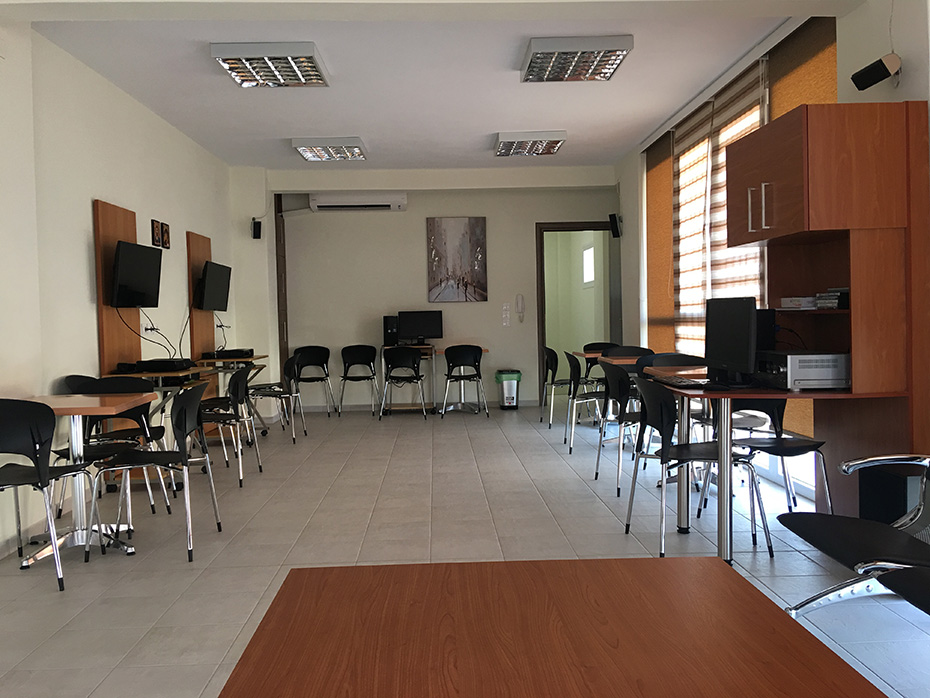 Ένα δωμάτιο με πολλά γραφεία και καρέκλες, το οποίο αποτελεί μέρος του Ενοριακού Κέντρου του Ιερού Ναού Κοιμήσεως Θεοτόκου Απαλού 