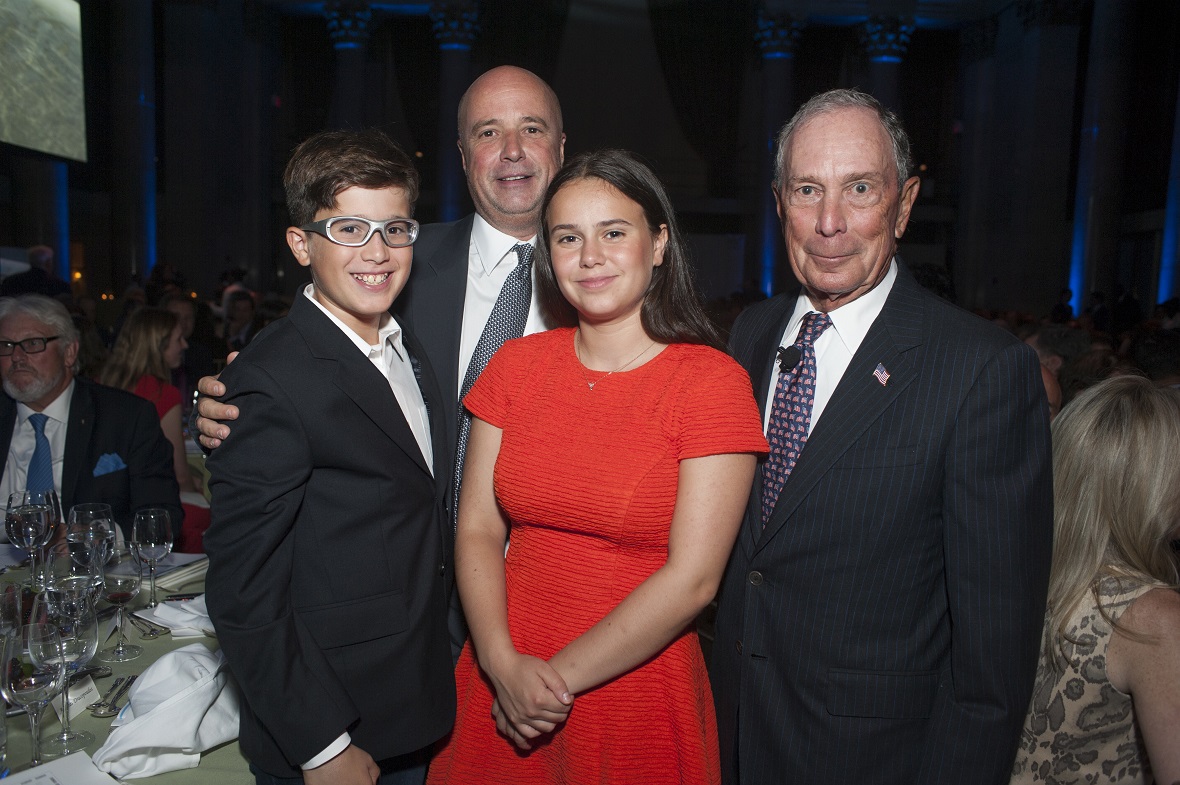 Andreas Dracopoulos, President of the Stavros Niarchos Foundation, poses with a man and two young children for a commemorative photo