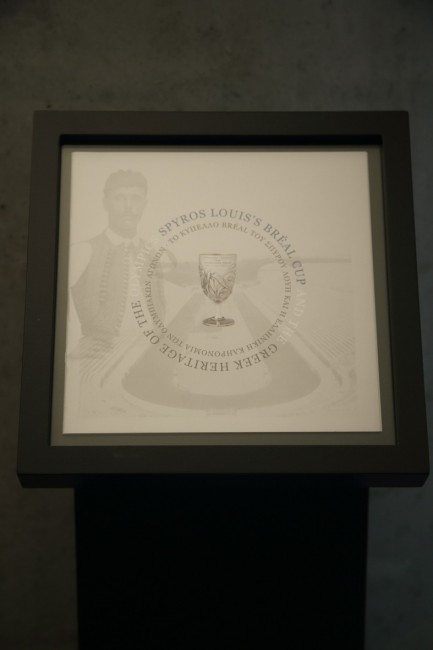 Φωτογραφία από ένα stand το οποίο έχει μια εικόνα που δείχνει αχνά το Καλλιμάρμαρο και στο κέντρο το κύπελο του Σπύρου Λούη