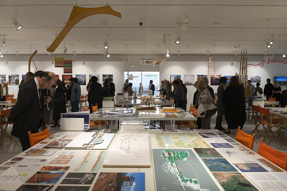 Φωτογραφία που δείχνει πλήθος κόσμου να περνάει και να κοιτάει τραπέζια στα οποία υπάρχουν σχέδια, υπομνήματα και μακέτες 