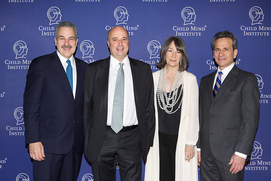 Ο Αντρέας Δρακόπουλος, Πρόεδρος του Ιδρύματος Σταύρος Νιάρχος, μαζί με δύο άλλους άντρες και μια γυναίκα στέκονται αγκαλιασμένοικαι χαμογελούν μπροστά από ένα Banner που γράφει child mind institute για μια αναμνηστική φωτογραφία
