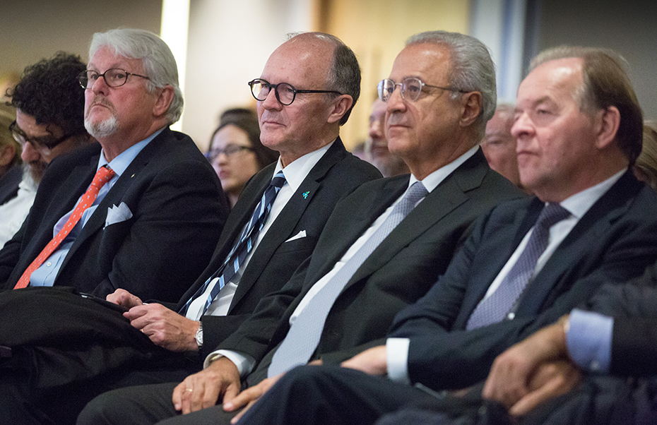 Τα μέλη του ακροατηρίου κάθονται και ακούν με προσοχή