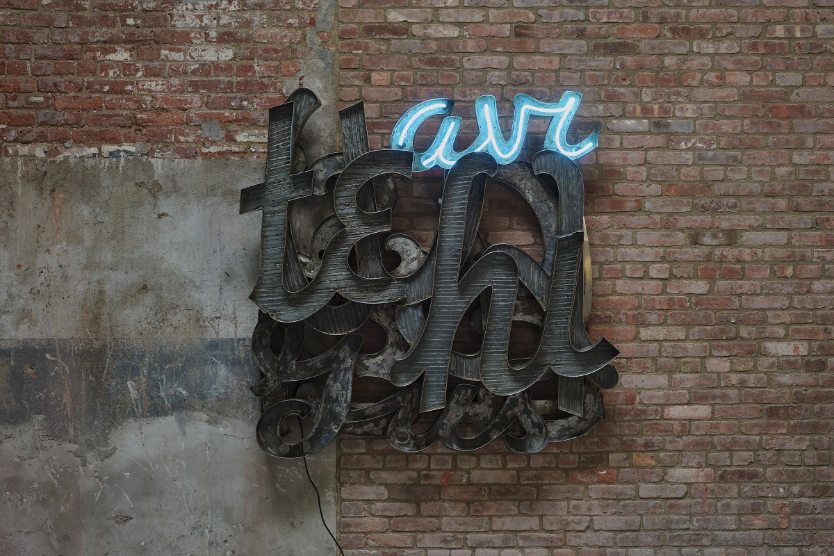 Ένα έργο τέχνης που αποτελείται από διαφορετικά γράμματα πάνω από έναν τούβλινο τοίχο.