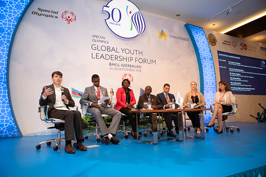Stavros Niarchos Foundation and Global Youth Leadership Forum members on stage, while a young man talks into the microphone