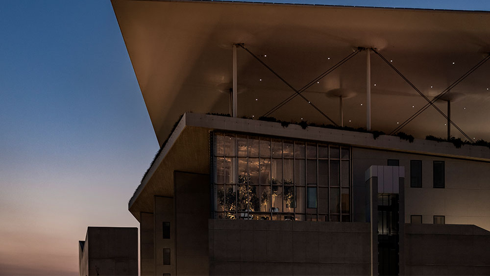 Φωτογραφία τραβηγμένη βραδινή ώρα που δείχνει μια μεγάλη τζαμαρία ενός κτηρίου 