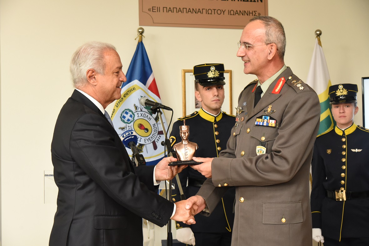 Ένας άνδρας λαμβάνει βραβείο από έναν άνδρα με στρατιωτική στολή