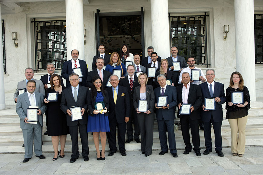 Μια ομάδα ανθρώπων που κρατούν επαίνους στα χέρια τους στέκονται στα σκαλιά για μια αναμνηστική φωτογραφία 