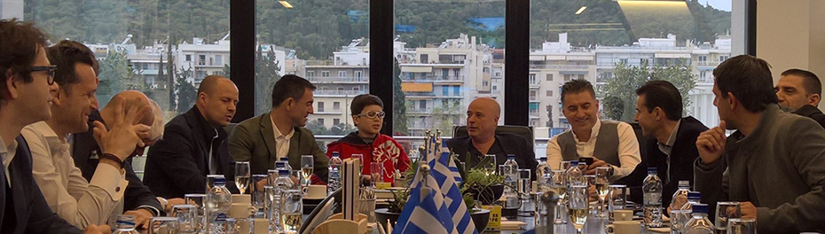 Μέλη της ελληνικής ομάδας των πρωταθλητών του Euro 2004 κάθονται και συνομιλούν με μέλη του Ιδρύματος Σταύρος Νιάρχος σε αίθουσα συνεδριάσεων