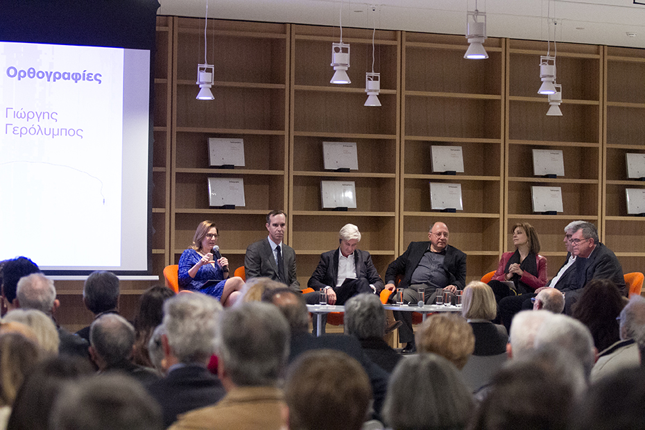 Σε μια σκηνή κάθονται έξι άνθρωποι με τη μορφή πάνελ εκ των οποίων μια γυναίκα κρατάει το μικρόφωνο και μιλάει και το κοινό από κάτω κάθεται σε καρέκλες και παρακολουθεί 