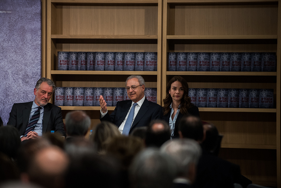 Τρία άτομα επί σκηνής στην παρουσίαση του βιβλίου του πρέσβη Βασίλη Κασκαρέλη 