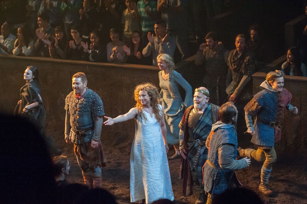 Μια ομάδα ηθοποιών παρουσιάζει μια παράσταση ενώ το κοινό που τους παρακολουθεί χειροκροτά