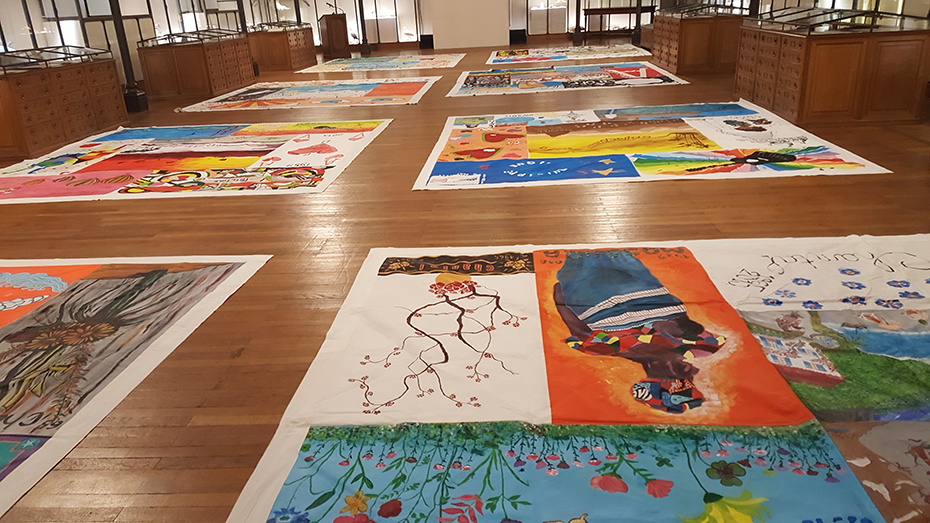 Στο πάτωμα ενός εσωτερικού χώρου είναι τοποθετημένα οκτώ μεγάλα ζωγραφισμένα πανιά 