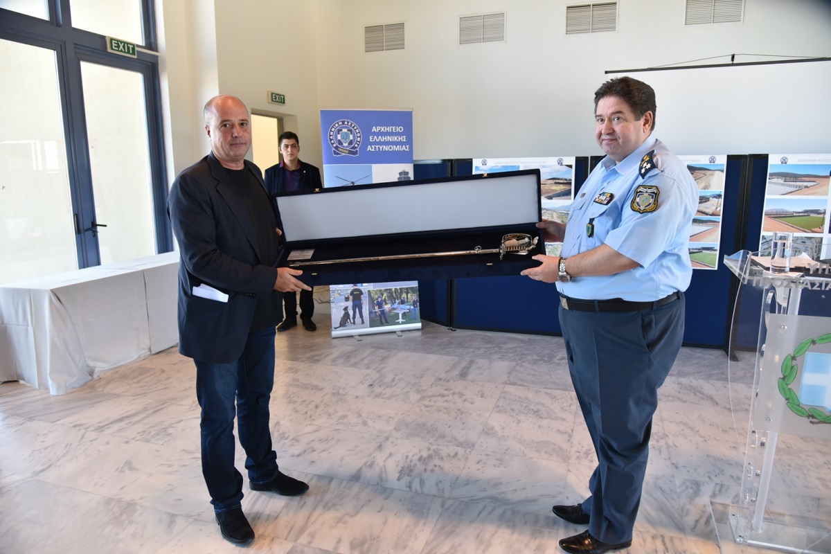 Ο Αντρέας Δρακόπουλος, Πρόεδρος του Ιδρύματος Σταύρος Νιάρχος κρατάει ένα δώρο τιμής μαζί με ένα αξιότιμο μέλος της Ελληνικής Αστυνομίας και φωτογραφίζονται 