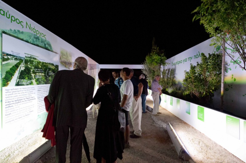 Σε έναν εξωτερικό χώρο έχει τοποθετηθεί μια κατασκευή σαν ένα ανοιχτό σπίτι στους τοίχους του οποίου υπάρχουν φωτογραφίες και σχόλια και ο κόσμος τα κοιτάει