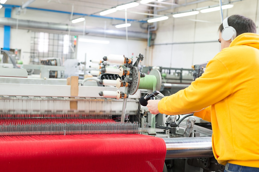 Ένας άνδρας χρησιμοποιεί μια μηχανή ύφανσης