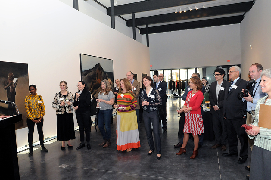 Φωτογραφία που δείχνει μια ομάδα ανθρώπων να στέκεται και να παρακολουθεί μια ομιλία 