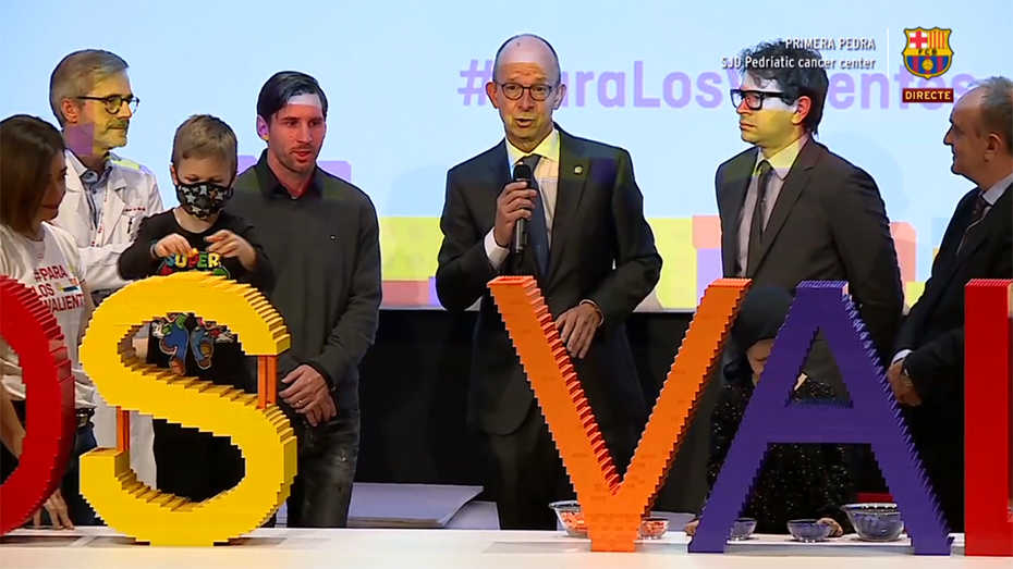 Μέλη του Ιδρύματος Σταύρος Νιάρχος στέκονται δίπλα στον Μέσι και ένα παιδί από το Παιδιατρικό Κέντρο Καρκίνου