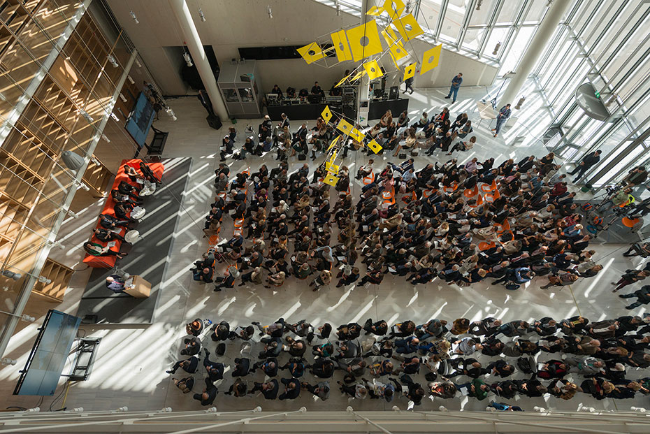 Άποψη από ψηλά του κόσμου που έχει συγκεντρωθεί στην Εθνική Βιβλιοθήκη και που κάθεται για να παρακολουθήσει μια παρουσίαση